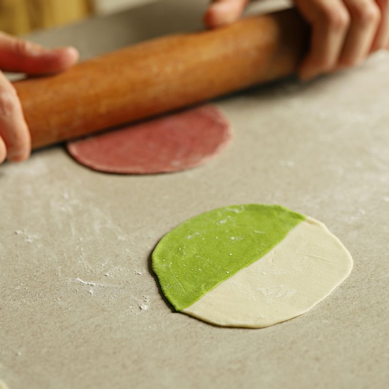 만두피를 반으로 잘라 다른 색의 반죽과 겹친 후 밀대로 밀어 붙여주세요.
(만두피는 0.5cm 이상으로 겹쳐야 만두가 터지지 않아요.)
