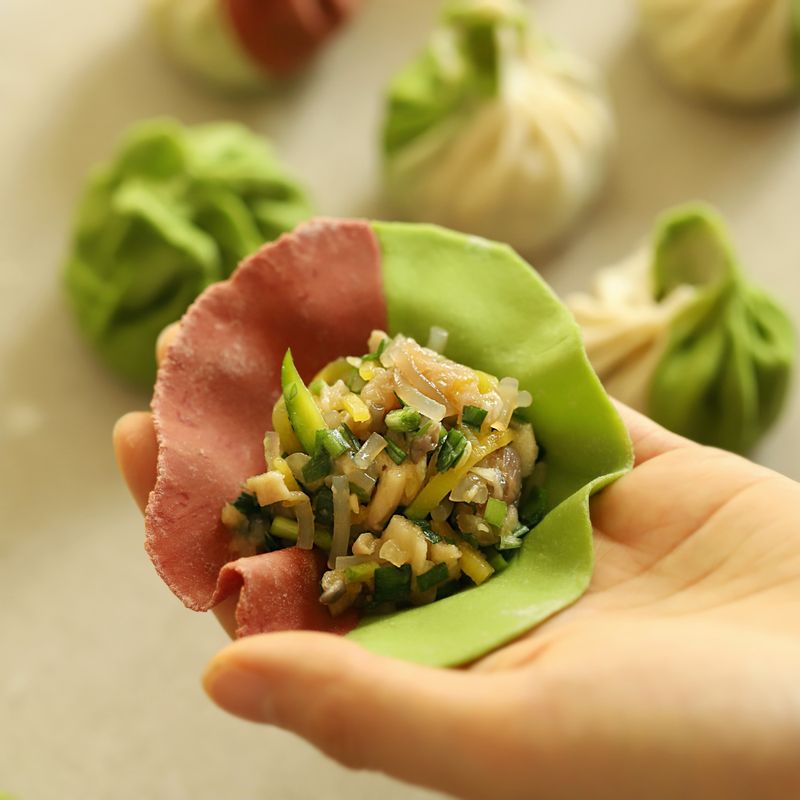 만두피에 만두소를 넣고 복주머니 모양으로 오므려 윗부분에 주름을 잡은 후 데친 부추로 묶어주세요. 김이 오른 찜통에 8~10분 정도 쪄주세요. 볼에 양념장 재료를 넣어 섞어주세요.