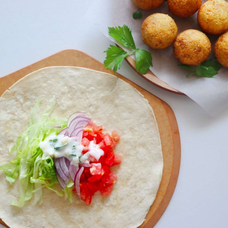 토르티야는 달군 팬에 올려 앞뒤로 부드럽게 구워주세요. 양상추, 양파, 토마토, 팔라펠을 올리고 머스타드와 요거트소스를 바른 후 말아주세요.