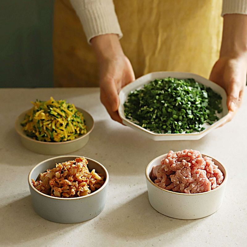 돼지고기는 키친타올에 올려 핏물을 빼주세요. 신김치, 부추는 잘게 썰고 신김치는 물기를 제거해주세요. 애호박은 채썰어 굵은소금에 5분 정도 절인 후 면포나 키친타월로 물기를 제거해주세요.