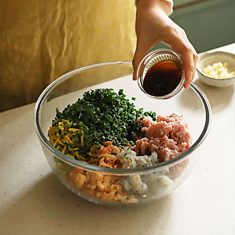 돼지고기에 만두 양념 재료를 먼저 조물조물 해준 후에 신김치, 부추, 애호박, 다진 새우를 섞어주세요.