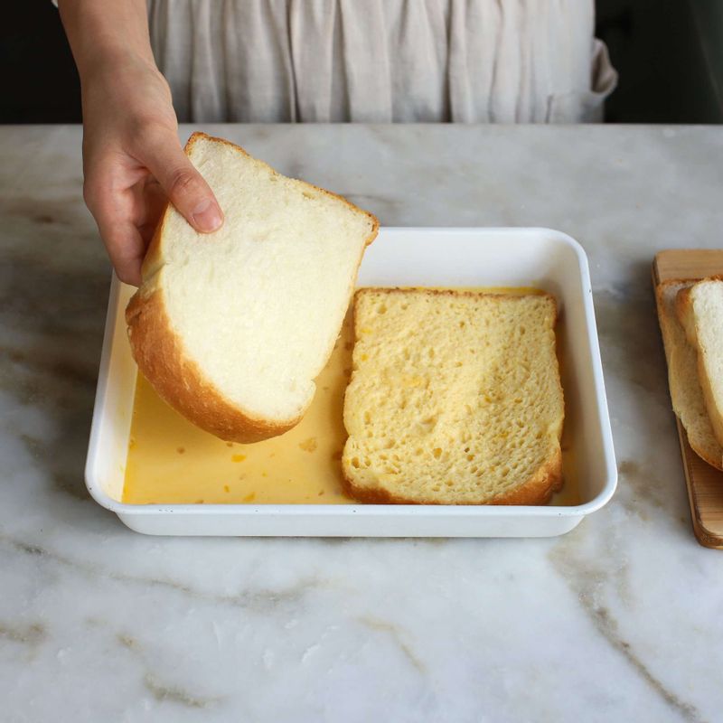 트레이에 빵을 놓고 완전히 젖을 때까지 두세요.