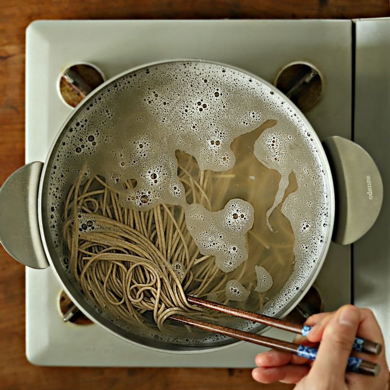 끓는물에 메밀면을 펼쳐 넣고 젓가락으로 저어 면끼리 달라붙지 않도록 저어주세요. 물이 끓어오르면 찬물 한 컵을 2~3회 반복해서 부어 국수를 삶아주세요. 흐르는 찬물에 면을 여러 번 씻어 전분기를 없애고 체에 받쳐 물기를 빼주세요.