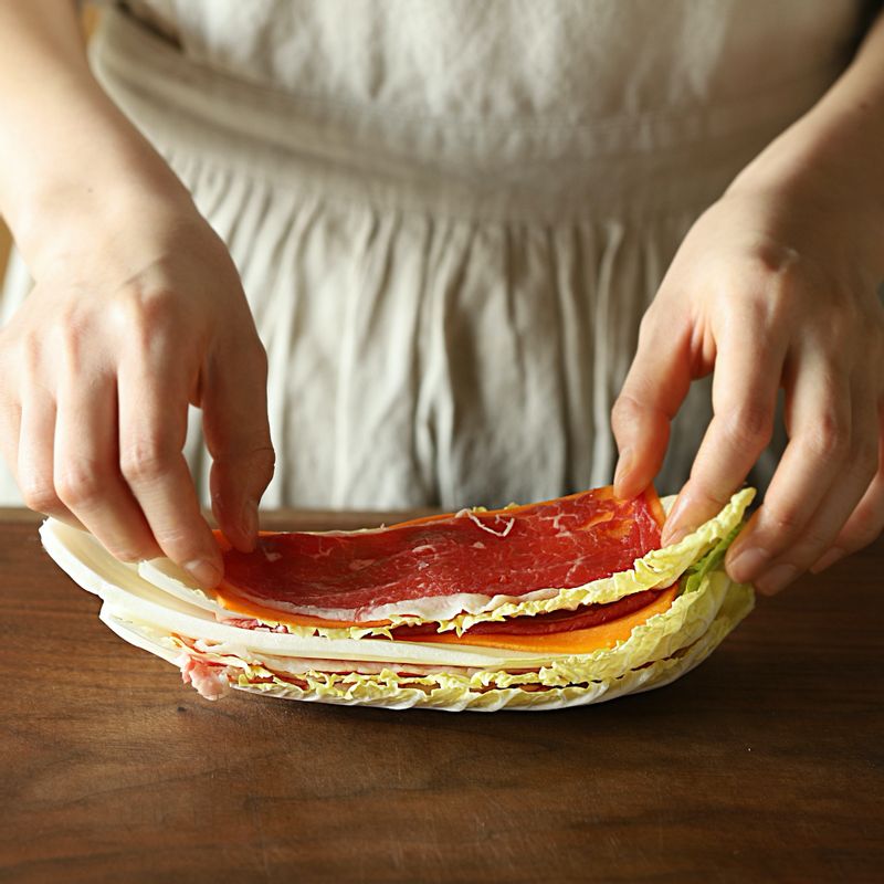 배추잎-당근-차돌박이 순으로 올리고 찜기의 높이에 맞춰 자른 후 찜기에 먹기 좋게 돌려 담아주세요. 찜기 가운데 깻잎을 깔고 버섯을 올려주세요.