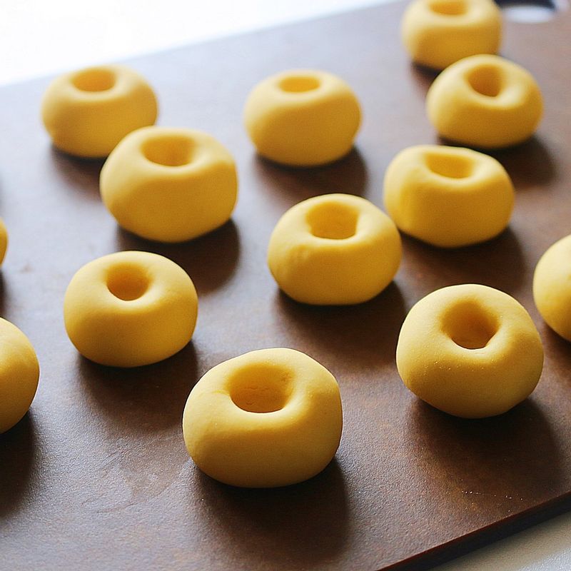 반죽을 20g 정도씩 떼어내서 동그랗게 빚은 후 가운데에 깊게 구멍을 내주세요.