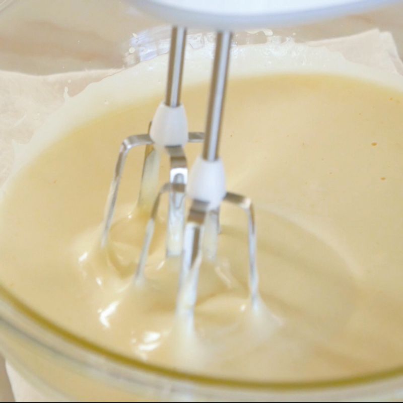 5. 순서3을 핸드 믹서로 뽀얀 아이보리 색이 나올 때까지 거품을 올려주세요.
(Tip! 믹서기를 들어 올려 지그재그로 움직였을 때 끝에 묻은 반죽이 아래로 떨어져 바로 사라지지 않고 몇 초 동안 남아 있으면 완성입니다. 이를 리본 상태라고 합니다.)
6. 체에 곱게 거른 박력분을 순서5에 넣고 밑에서 위로 올리면서 거품이 죽지 않도록 가볍게 섞어주세요.
7. 그 사이 중탕해서 녹은 버터에 만들어 놓은 반죽의 일부를 덜어서 믹싱하다가 남은 반죽에 다시 붓고 잘 섞어줍니다.