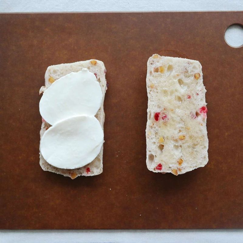 치아바타를 반으로 가르고 빵의 양면에 각각 꿀 1/2큰술씩 발라주세요. 빵 한쪽에 모차렐라치즈 절반 분량을 올려주세요.