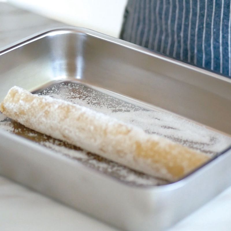 8. 넓적한 그릇에 설탕을 뿌리고 숙성된 반죽을 올려 굴려주세요.
(Tip! 반죽 겉면에 달걀물을 살짝 바르면 설탕이 조금 더 잘 묻어요.)
9. 설탕이 골고루 묻은 반죽을 도마 위에 올려두고 7~8mm 두께가 되도록 잘라주세요.
10. 순서9를 오븐 팬에 적당한 간격을 띄어 팬닝하고 미리 예열한 오븐에서 170도로 15~20분간 구워주세요.