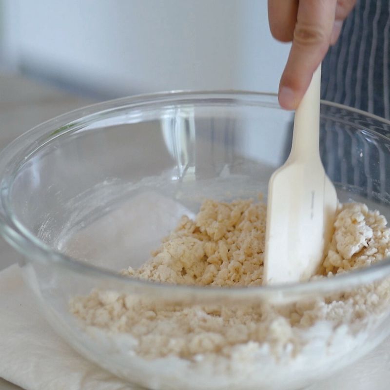 4. 적당히 섞이기 시작하면 소보로 상태가 되도록 뒤섞어주세요.
(Tip! 반죽이 고운 알갱이가 될수록 입에 넣었을 때 바삭한 느낌과 부드러운 식감이 납니다.)
5. 순서4의 반죽을 한 덩어리로 뭉쳐주세요.
(Tip! 만약 한 덩어리로 잘 뭉쳐지지 않는다면 손바닥으로 여러 번 꾹꾹 눌러 작업하세요.)
6. 작업대 위에 반죽을 올리고 손바닥으로 밀어 지름 3cm 크기로 길고 동그랗게 만들어주세요.
7. 유산지 위에 순서6을 올리고 돌돌 말아준 뒤 냉동실에서 넉넉히 3시간 동안 숙성시킵니다.
(Tip! 만약 냉동실에 넣은 지 1시간이 지났음에도 제법 단단해졌다면 꺼내서 다음 작업으로 넘어가도 됩니다.)