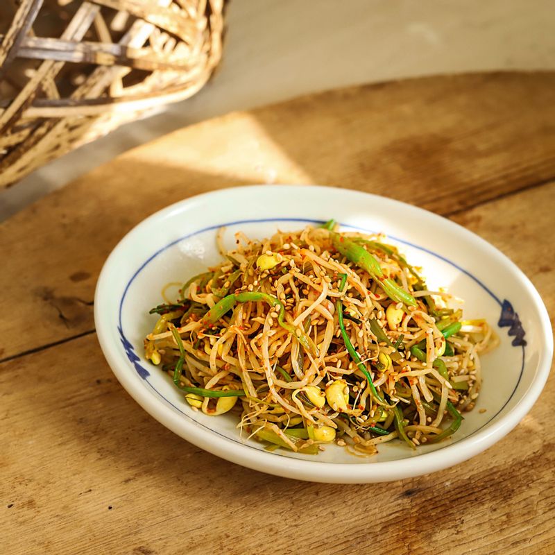 완성된 콩나물 미나리 무침을 그릇에 담고 통깨를 뿌려 맛있게 즐겨주세요.