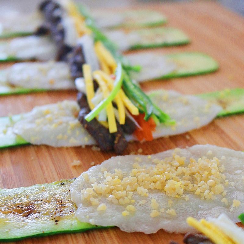 애호박 위에 찹쌀전병-잣가루-쇠고기-당근-오이-지단 순으로 얹은 후 돌돌 말아주세요.