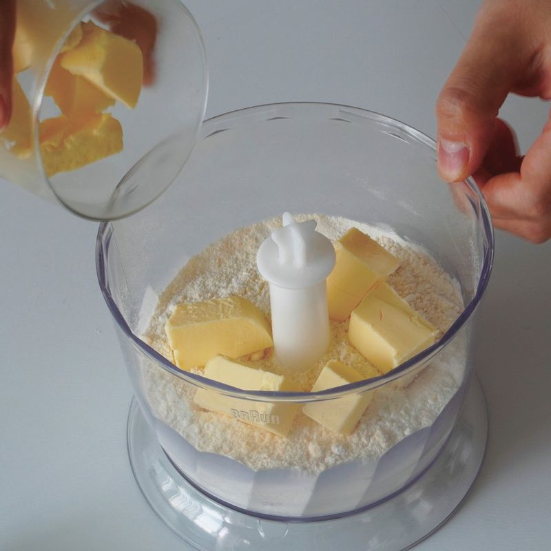 차갑게 준비한 버터를 넣고 팥알 크기로 갈아주세요.
(tip. 모든 재료를 차갑게 준비하는 이유는 버터가 많이 녹을수록 바삭한 식감이 떨어지기 때문에, 가루 재료까지 모두 차갑게 준비하면 성형을 하고 나서도 좋은 상태의 반죽을 완성할 수 있어요.)