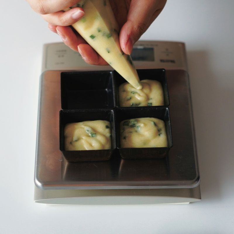 순서5의 반죽을 짤 주머니에 담고 틀에 반죽 20g을 짠 후 가운데에 가문어 5g을 넣어준 뒤 반죽 7g씩을 더 짜서 위를 덮어주세요.