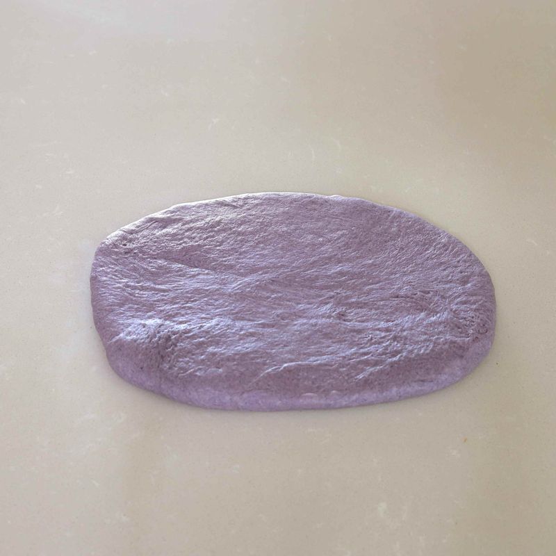 7. 반죽의 매끈한 면을 바닥에 놓고 손으로 가볍게 눌러 가스를 뺀 후 가로 20cm, 세로 30cm가 되도록 밀대로 밀어줍니다. 반죽의 가로 폭이 팬의 가로 폭을 넘지 않도록 주의해주세요.
8. 밀대로 충분히 민 반죽을 돌돌 말아준 뒤 이음매 부분을 꼬집어 여며주세요.