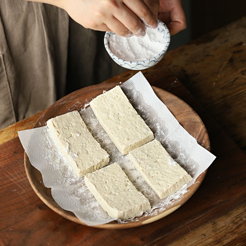 두부의 겉면에 전분을 입혀주세요. 달군 팬에 기름을 약간 두른 후 두부와 버섯을 넣고 노릇하게 구워주세요. 구운 두부와 버섯에 만들어둔 양념장을 넣어 졸여주세요.