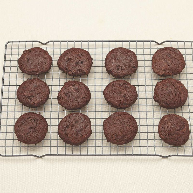 8. 180℃로 예열된 오븐의 가운데 칸에서 10분간 구운 후 식힘망에 올려 식혀주세요.
(tip. 굽는 중간에 팬을 한 번 돌려주면 골고루 구워져요. 팬의 크기에 따라 2회로 나눠 구워요.)
*Tip : 굽는 시간에 따라 식감이 달라져요!
브라우니 쿠키를 8분간 구우면 퍼지 브라우니처럼 찐득한 식감의 쿠키가 되고, 12분 이상 구우면 좀 더 바삭한 식감의 초콜릿 쿠키가 만들어져요. 기호에 따라 굽는 시간을 조절해 보세요. 단 15분 이상 구우면 수분이 많이 증발 되어 딱딱한 쿠키가 될 수 있으니 15분 이상 굽지마세요.