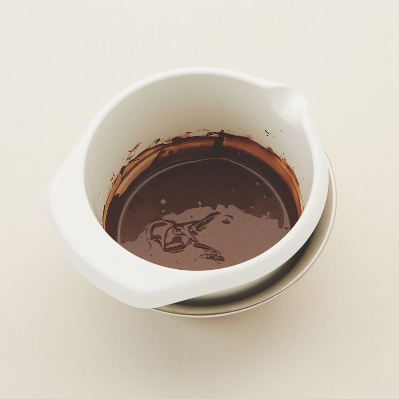 *시작하기 전에
1. 달걀은 1시간 전에 냉장실에서 꺼내 실온에 두어주세요.
2. 박력분, 베이킹파우더는 함께 체 쳐주세요.
3. 다크커버춰 초콜릿은 잘게 다져주세요.
1. 큰 볼에 뜨거운 물을 넣고 그 위에 잘게 다진 다크커버춰 초콜릿을 넣은 볼을 올려 중탕하여 녹인 후 버터를 넣고 녹여주세요.
2. 중탕 볼에서 내린 후 황설탕, 소금을 넣고 거품기로 섞어주세요.
(tip. 설탕 양이 많은 반죽이에요. 다 녹지 않고 서걱거리는 느낌이 들어도 걱정하지 마세요.)
3. 달걀을 하나씩 넣어가며 거품기로 재빨리 섞어주세요.
(tip. 달걀이 익어 덩어리 질 수 있으니 재빨리 섞어주세요)