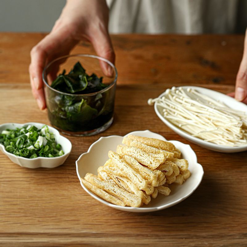 쪽파는 송송 썰고 유부는 채를 썰어주세요. 불린 미역은 잘게 썰고, 팽이버섯은 밑동을 잘라 먹기 좋게 찢어주세요.