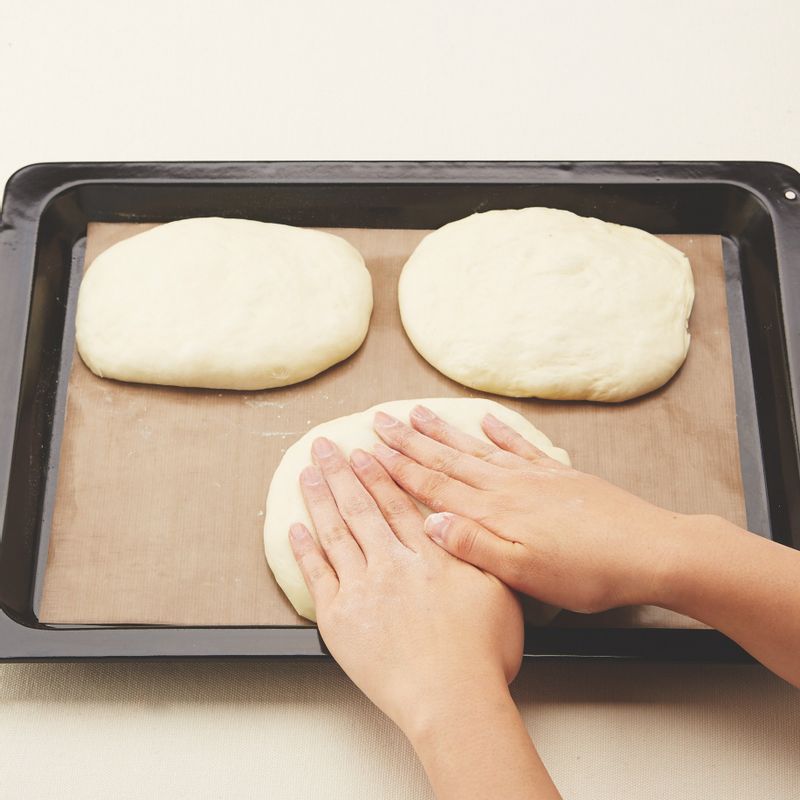 7. 유산지를 깐 오븐 팬 위에 올리고 덧밀가루를 바른 손바닥으로 살살 눌러 모양을 잡아요.
8. 젖은 면보(또는 비닐)를 덮은 후 따뜻한 곳(28~30℃)에서 45~50분간 2차 발효시켜주세요.
(tip. 치아바타는 중간 발효가 없어요, 모양을 잡은 후 바로 2차 발효하세요.)
9. 작은 체로 윗면에 장식용 강력분을 뿌려주세요.