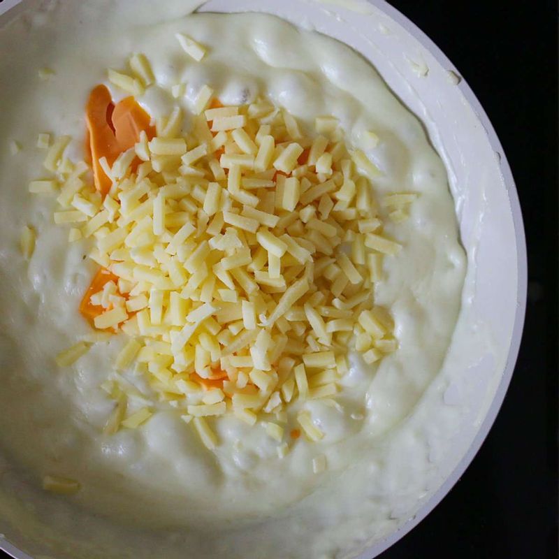 우유를 넣어 밀가루가 뭉치지 않게 풀어준 후 피자치즈와 체다치즈를 넣어주세요.