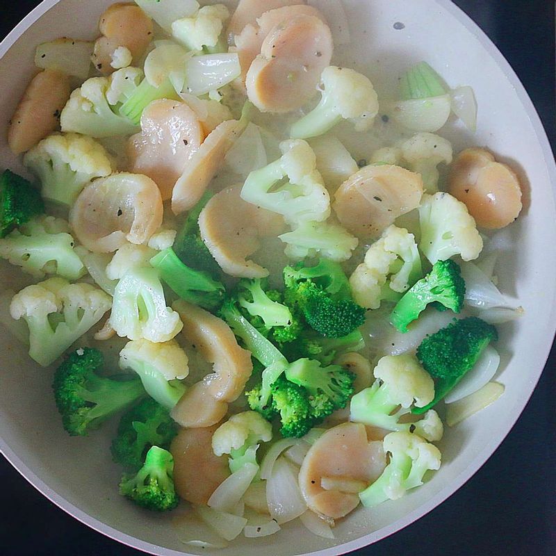 달군 팬에 올리브오일을 두르고 마늘, 양파, 관자를 볶다가 브로콜리와 콜리플라워를 넣고 소금과 후추로 간을 해 볶아주세요.