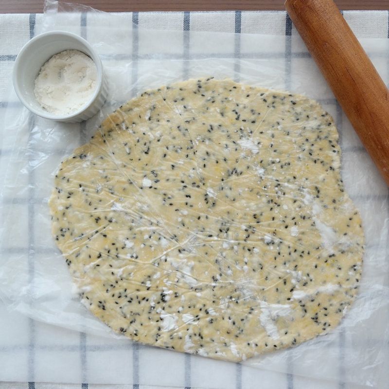 평평한 바닥에 비닐을 깔고 덧밀가루를 뿌리고 반죽을 올린 후 위에 덧밀가루를 뿌리고 그 위에 비닐을 덮어서 밀대로 밀어주세요. 중간중간 덧밀가루를 뿌려주어야 반죽이 비닐에 붙지 않아요.