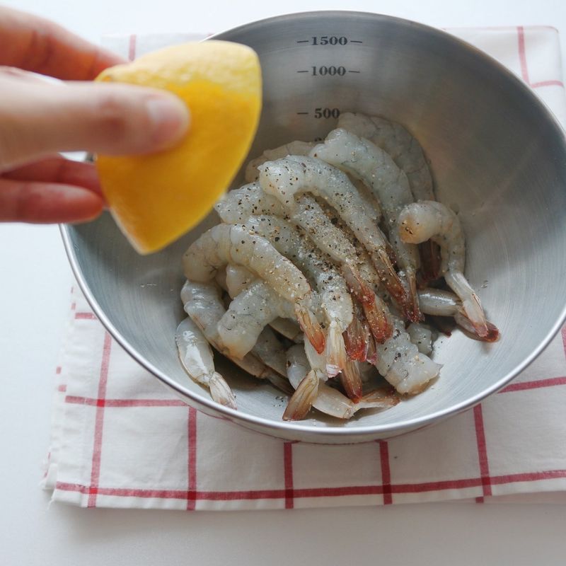 새우는 꼬리 껍질을 제외하고 머리와 몸통의 껍질을 모두 제거해주세요. 새우 등과 배의 내장을 꼬치로 제거한 후 꼬리에 있는 물총을 가위로 잘라주세요.
손질한 새우는 밑간을 하여 10분간 재워두었다 물기를 키친타월로 제거해주세요.