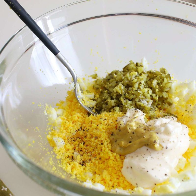 달걀흰자는 굵게 다지고, 노른자는 체에 곱게 내려주세요. 볼에 달걀, 피클, 소스 재료를 넣고 잘 섞어주세요.