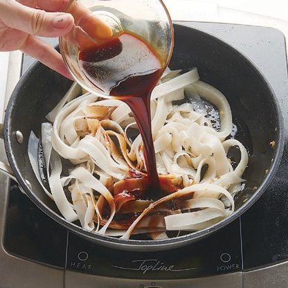 달궈진 팬에 식용유를 두르고 다진 생강을 볶아 향을 내주고 물에 불린 쌀국수를 볶아가며 소스를 넣고 졸여주세요.