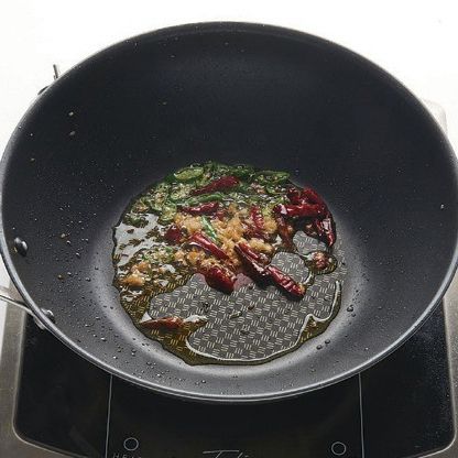 달궈진 팬에 식용유를 두르고 다진 마늘, 다진 생강, 청양고추, 마른 고추를 넣고 볶아서 매콤한 향을 내줍니다.