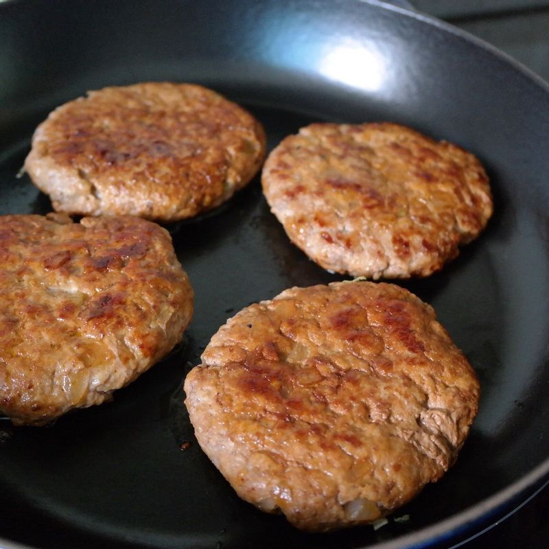 베이컨은 이등분하고 팬에 노릇하게 구워준 후 키친타월로 기름기를 제거해주세요. 패티용다진 양파는 팬에 기름을 살짝 두르고 볶은 후 한 김 식혀주세요.
큰 볼에 다진 쇠고기, 돼지고기, 볶은 다진 양파와 케첩, 우스터소스, 소금, 후추를 넣고 치대어주세요.
동그랗게 빚은 후 기름을 두른 팬에 올려 앞뒤로 노릇하게 구워주세요. 패티 위에 바비큐소스를 한 큰술 발라주면 바비큐 맛 햄버거를 만들 수 있어요.