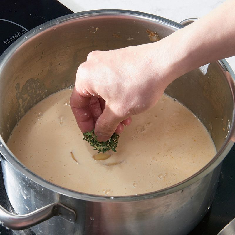 걸러낸 옥수수 스프에 으깬 생강과 타임을 넣어 약불로 15분간 더 끓여주세요.
