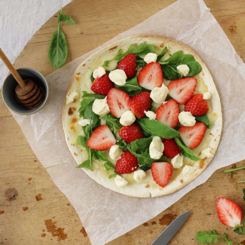 토르티야에 루꼴라(샐러드 잎채소)와 딸기를 골고루 올린 후, 크림치즈 토핑을 티스푼으로 떠서 군데군데 올려주세요.