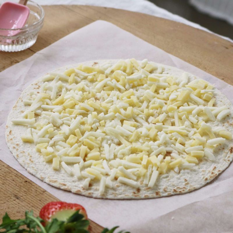 토르티야에 꿀을 펴 바른 후 피자치즈를 골고루 올리고, 200도로 예열한 오븐에서 치즈가 녹을때까지 7분 정도 구워주세요.
(팬을 이용하실 때는 뚜껑을 닫고 약한 불에서 6~8분간 치즈가 녹을 때까지 익혀주세요.)