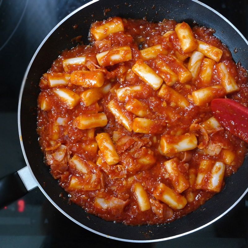 기름을 두른 팬에 다진 마늘과 다진 양파를 넣고 볶다가 향이 올라오면 토마토소스, 올리고당, 고추장을넣어주세요.
냄비에 물을 넣고 끓으면 떡을 살짝 데쳐서 부드럽게 만들어주세요. 양념에 떡과 베이컨을 넣고 간이 배도록 조려 떡볶이를 만들어주세요.