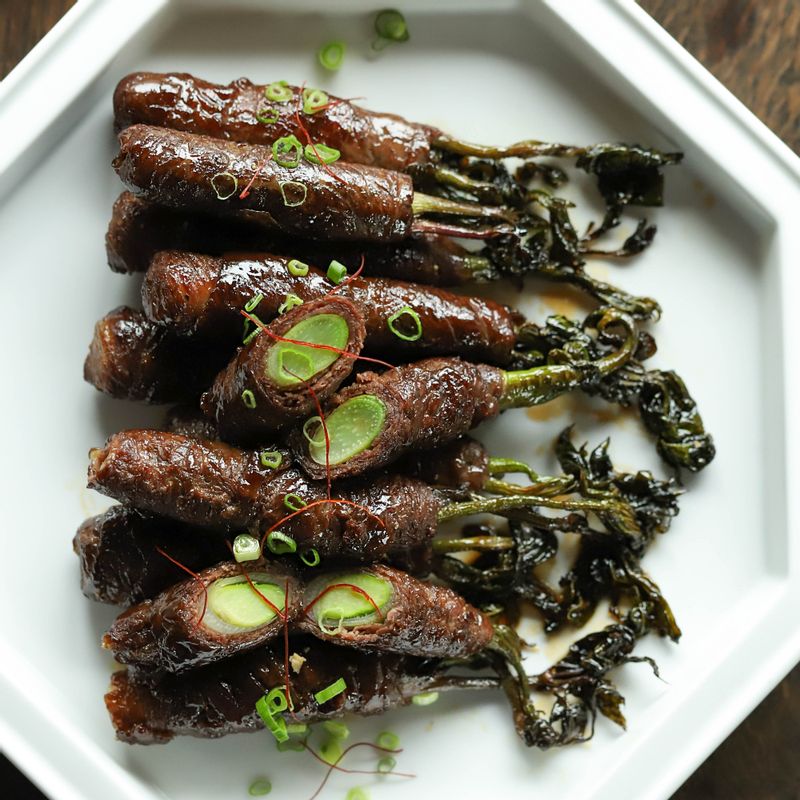 완성된 두릅 소고기 말이를 접시에 담고 고명을 올려 장식한 후 맛있게 즐겨주세요.