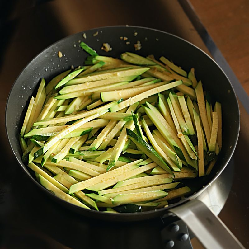 프라이팬에 기름을 약간 두르고 다진 마늘을 볶다가 향이 올라오면 채썬 호박과 다진 파를 넣고 후추를 뿌려 1~2분간 볶아주세요.