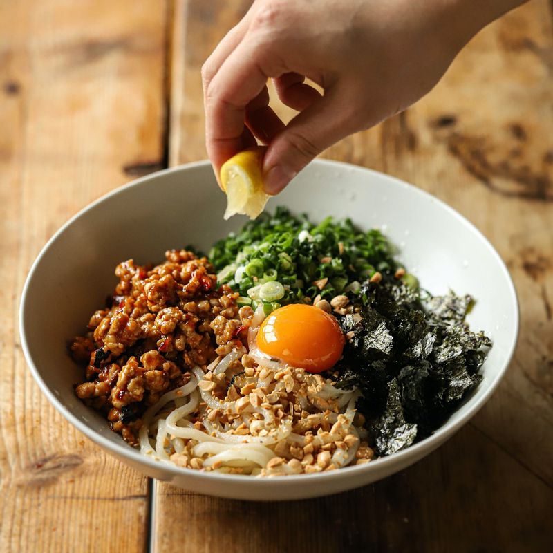 그릇에 삶은 면을 담고 쪽파와 볶은 고기, 부순 김과 땅콩, 통깨를 뿌린 후 가운데 달걀노른자를 올려주세요.
(tip. 통깨를 손바닥으로 가볍게 부숴 넣으면 더욱 고소해요)