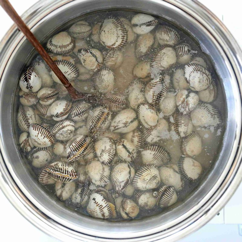 끓는 물에 꼬막과 청주 1큰술을 넣고 젓가락을 이용해 한 방향으로만 휘휘 저어 주세요. 꼬막이 입을 벌리기 시작하면 불을 끄고 잘 익은 꼬막을 건져 살과 껍질을 분리해주세요.