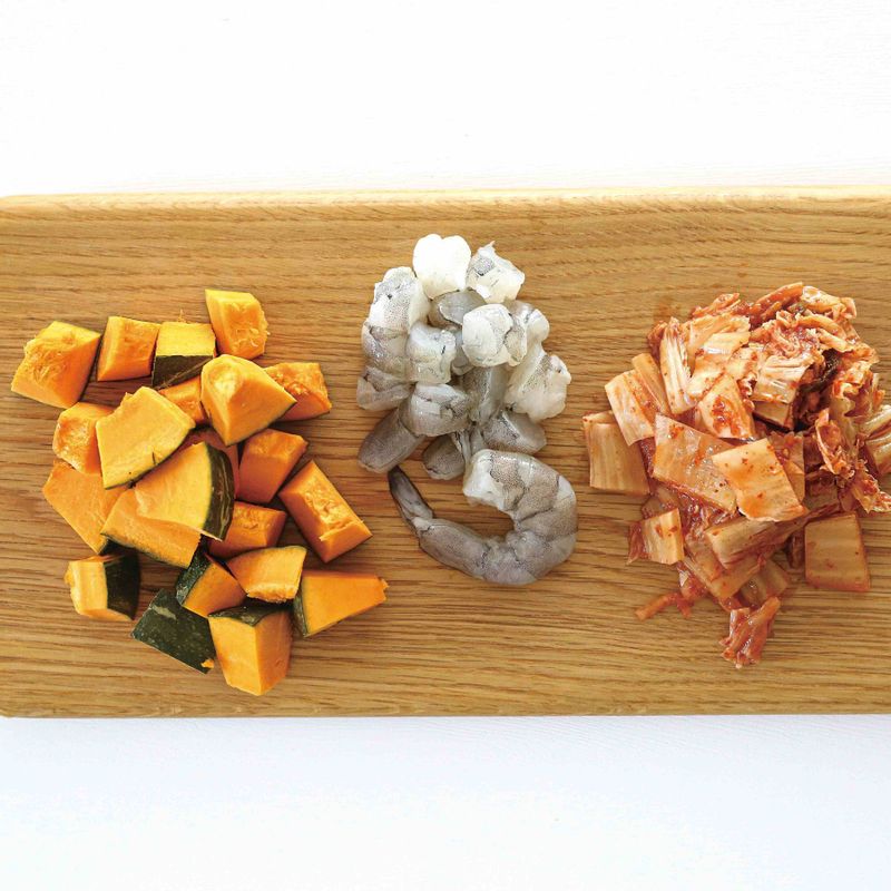 단호박은 잘 씻어 껍질째 큐브 모양으로 썰고, 익은 김치는 속을 털어낸 뒤 잘게 썰어 준비해주세요. 새우도 깨끗이 씻어 머리 부분을 떼어내고 껍질을 벗겨 1cm 길이로 썰어주세요.