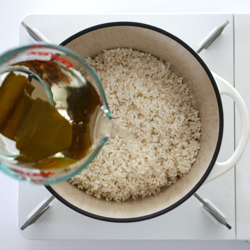 솥에 불린 쌀을 넣고 다시마 냉침 육수 300ml를 부어 센 불에서 5분간 끓여주세요. 끓기 시작하면 약불로 줄여 10분간 밥을 지어주세요.