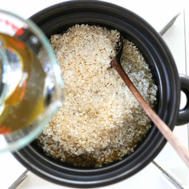 솥에 불린 쌀을 넣고 연어 숙성 양념 2큰술을 골고루 뿌려주세요.