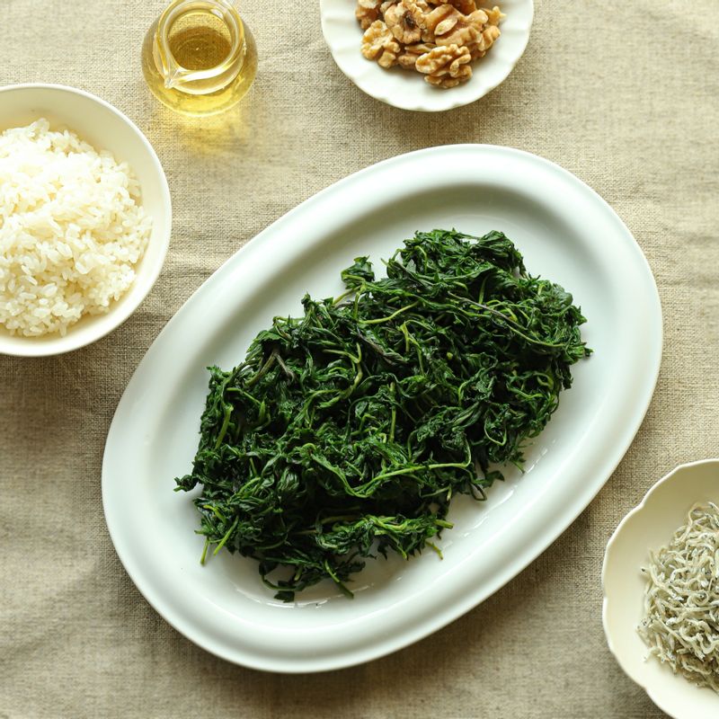 쑥 주먹밥을 위한 재료 이미지로 데친 쑥,잔 멸치,다진 견과류,통깨,밥 등으로 구성 되어있습니다.