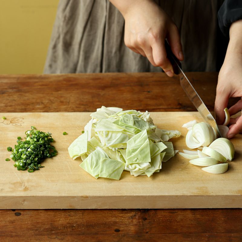 양배추는 한입 크기로 썰어주세요. 양파는 두껍게 채를 썰어 주세요. 쪽파는 종종 썰어주세요.