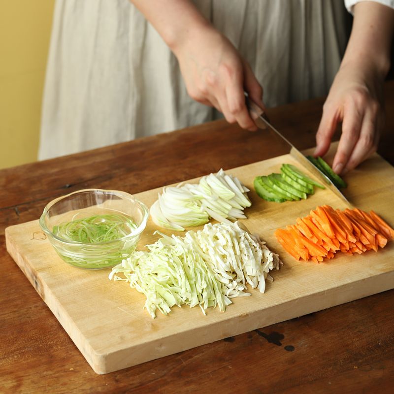 양배추와 당근, 양파, 대파는 채를 썰어주세요. (대파 채는 찬물에 담갔다가 물기를 빼 주세요) 오이는 길이로 반 갈라 어슷하게 슬라이스 해 주세요.