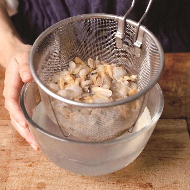 바지락젓갈은 찬물에 세 번 정도 씻어주세요. (바지락젓갈을 볼에 넣어 씻고 체망으로 건진 후, 다시 볼에 찬물을 담아 씻는 것을 세 번 정도 반복해 주세요.)
*Tip. 바지락젓갈은 염장할 때 이미 완전히 삭혔기 때문에 물에 씻어 조리해도 빨리 상하지 않는답니다!