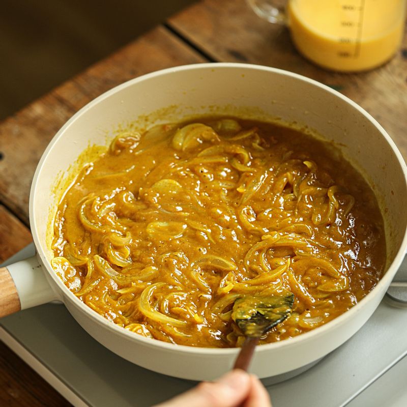 카레 가루를 넣어 뭉치지 않도록 섞은 후 달걀 물을 넣어 약불에서 천천히 저어주세요.