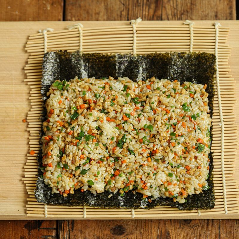 김발에 김을 깔고 섞어 둔 밥을 고르게 펼친 후 김밥을 단단하게 말아주세요.
(tip.밥의 끝과 김이 맞닿게 말면 더욱더 예쁘게 만들 수 있어요)