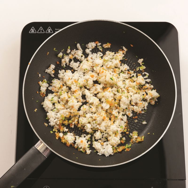 다른 팬에 카놀라유를 두르고 다진 양파를 중불에서 볶아주세요. 양파가 어느 정도 익으면 잘게 다진 당근, 애호박을 넣고 볶은 뒤 밥을 넣어 1분간 더 볶아주세요.