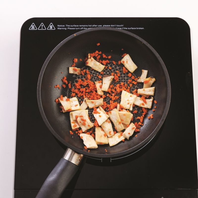 달군 팬에 카놀라유를 두르고 잘게 다진 당근과 슬라이스한 새송이버섯을 넣고 중불에서 3분간 볶아주세요.